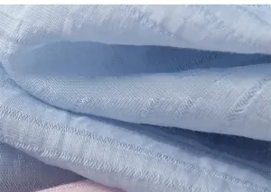 Detailed macro shot of light blue and pink striped seersucker fabric texture
