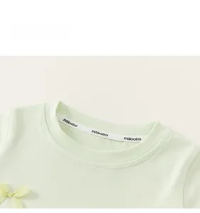 Nahaufnahme eines minzgrünen T-Shirt-Ausschnitts mit einer süßen gelben Satinschleife