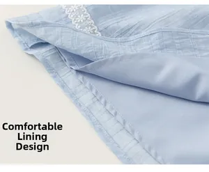 Detailed view of light blue dress hem with floral embroidery lace and soft inner lining