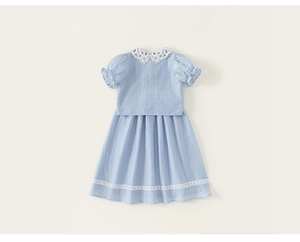 Detail shot of light blue girls' dress with delicate white lace collar and textured fabric