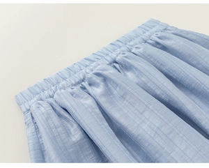 Detail of light blue girls skirt featuring elastic high waist and vertical striped texture