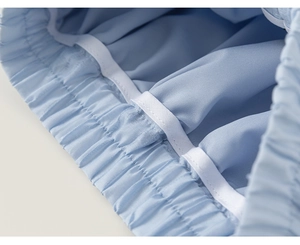 Detailed close-up of light blue elastic waistband with white internal hanging loops