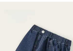 Detail of kids denim shorts featuring elastic waist, contrast stitching, and a grey button