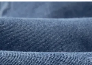 Detailed macro view of the premium blue denim fabric showing soft cotton texture and weave