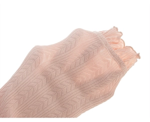 Detail of pink knitted girl's leggings featuring delicate mesh texture and ruffled edge