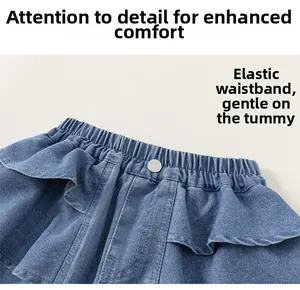 Detailed view of elastic waistband with silver button and ruffle trim on blue denim shorts