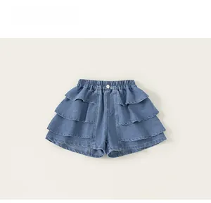 Detail view of denim shorts for girls featuring three-layer ruffles and elastic waist