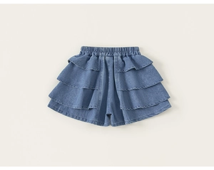 Detail of girls layered denim skort featuring three tiers of ruffled hem and elastic waist