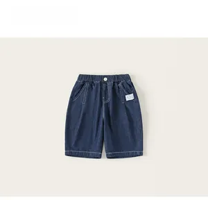Detail of dark blue denim shorts featuring elastic waist, white button, and contrast stitching