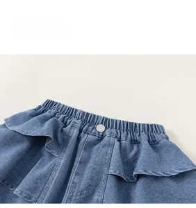 Detailed macro view of girls denim skirt shorts featuring elastic waist and ruffle layers