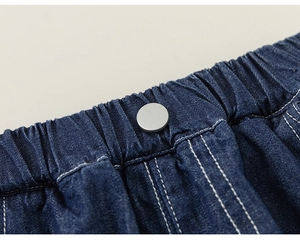 Detail of deep blue denim shorts featuring elastic waistband and white contrast stitching