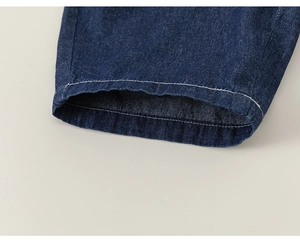 Detail of dark blue denim hem with white stitching and textured twill fabric