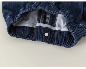 Detail of kids elastic waistband denim shorts with reinforced stitching and silver button