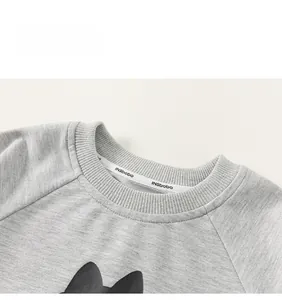 Close-up of ribbed crew neck and logo tape on children's grey raglan sweatshirt