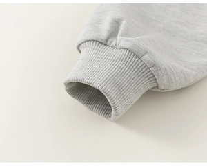 Close-up of ribbed knit cuffs on gray children's sweatshirt with detailed fabric texture