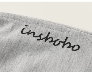 Macro shot of grey cotton knit fabric with black inshobo letter print on the garment