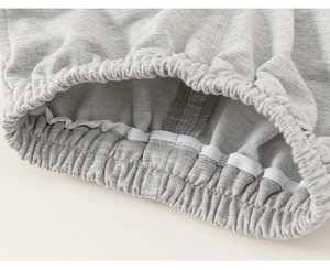 Detail of grey cotton French terry fabric with elastic ribbed cuffs and white reinforced tape