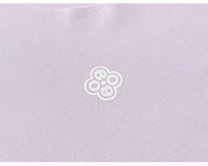 Détail du tricot violet clair avec impression graphique de trèfle blanc et texture lisse
