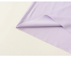 Gros plan du haut enfant lavande montrant l'ourlet sans couture et la texture fine