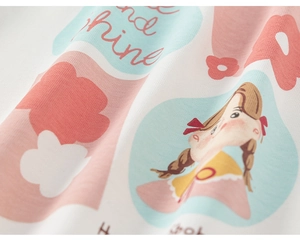 Detail of soft white knit fabric with a cute cartoon girl print and Shine lettering