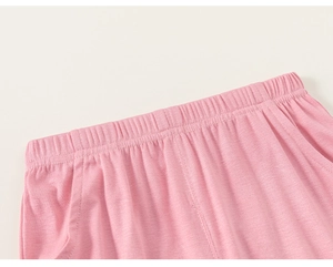 Detail view of pink knit children trousers featuring elastic waistband and side pockets