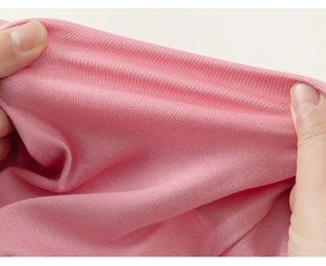 Detail shot of premium pink ribbed knit cotton fabric showing soft texture and elasticity