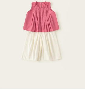 Dettaglio del top senza maniche plissettato rosa e pantaloncini larghi beige estivi