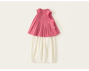 Dettaglio di top a pieghe rosa senza maniche e pantaloni casual bianco crema da bambina