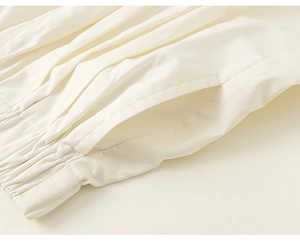 Dettaglio dei pantaloni avorio da bambina con elastico in vita e cucitura della tasca