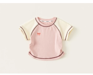 Close-up of baby girl cotton raglan t-shirt showing the bow print and knit texture
