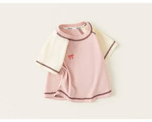 Detailed macro view of the pink cotton t-shirt with orange bow print and side ruching