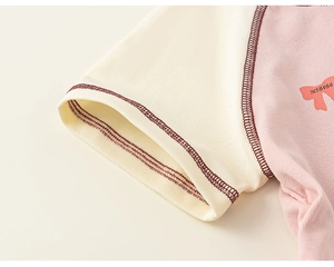Close-up of pink cotton t-shirt for girls featuring bow print and raglan sleeve stitching
