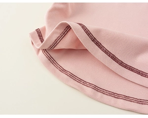 Detail of pink ribbed fabric hem featuring high-quality double-needle stitching and neat seams