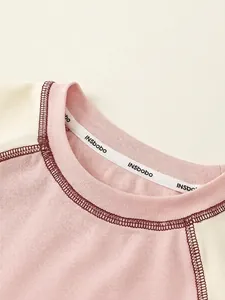 Close-up of pink raglan sleeve toddler t-shirt with ribbed neck and INSbobo label