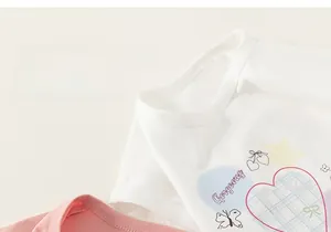 Détails du col rond et des imprimés mignons sur des t-shirts en coton rose et blanc fille