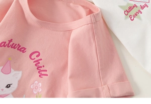 Gros plan d'un t-shirt en coton rose montrant l'imprimé chat et la texture du col doux