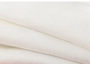 Gros plan sur le tissu en coton blanc gaufré montrant la texture douce et les détails côtelés
