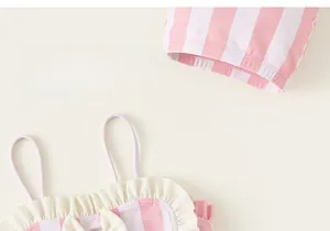 Détail d'un maillot de bain rayé pour filles avec froufrous et décoration de nœud mignon