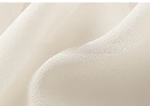 Vue macro d'un tissu tissé blanc perle léger avec une texture douce et un drapé élégant
