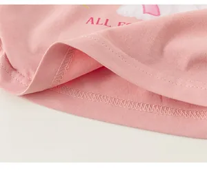 Gros plan du tissu en coton rose montrant l'ourlet à double aiguille et les détails d'impression