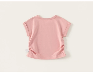 Détail d'un t-shirt rose en coton pour fille avec des fronces latérales élégantes et plis