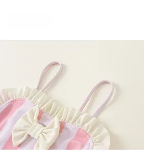 Détail du maillot de bain rayé rose et violet pour filles avec nœud crème et col à volants