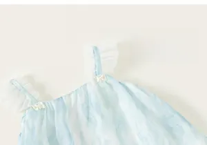 Détail d'une robe bleu clair avec volants en résille blanche, petits nœuds et perles fines