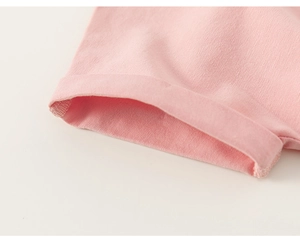 Gros plan détaillé de la couture du revers sur un t-shirt rose en coton pour filles