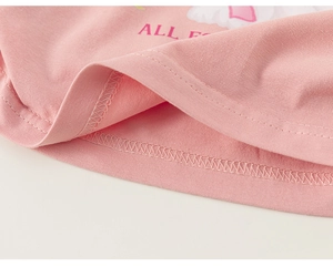 Détail d'un t-shirt rose en coton pour fille avec texture en maille et ourlet à double couture