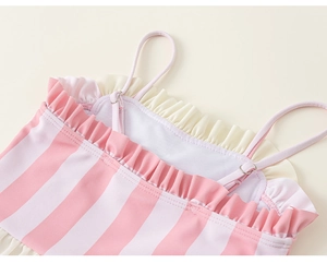 Détail d'un maillot de bain à rayures roses et blanches pour filles avec des volants