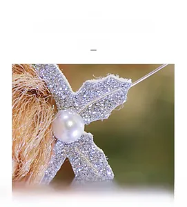 Macro shot of faux pearl decoration with glittery silver leaves and brown faux fur detail