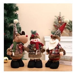 Drei Weihnachtsfiguren aus Stoff auf Holzkamin mit festlichem Hintergrund im Wohnzimmer