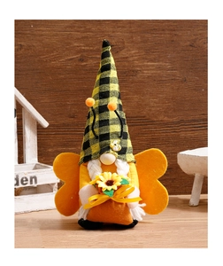 Detail of bee gnome plush with yellow wings holding a sunflower on wood background
