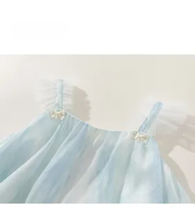 Détail de la robe en tulle dégradé bleu pour fille avec bretelles volantées et nœud perlé